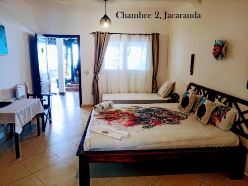 a bedroom with a bed in a room with a table at Ô Bleu Azur in Antsatrakolo