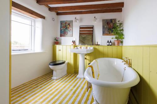 a bathroom with a tub and a sink and a toilet at 15 Bond Street By The Butler Collection in Arundel