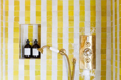 a shower with two bottles of wine on a shelf at 15 Bond Street By The Butler Collection in Arundel