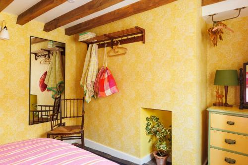a bedroom with a yellow wall with a fireplace at 15 Bond Street By The Butler Collection in Arundel