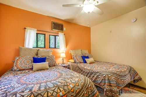 two beds in a room with orange walls at Quiet Home with Garden about 7 Mi to Patagonia Lake! in Patagonia