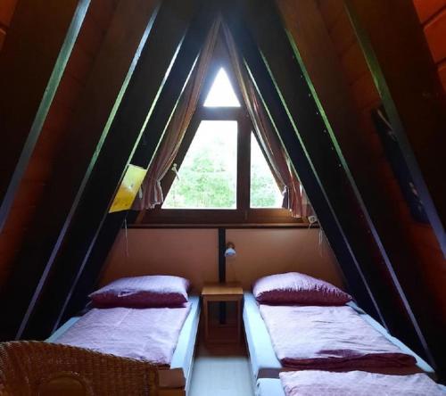 two beds in a small room with a window at Ferienhaus Toso in Freyung