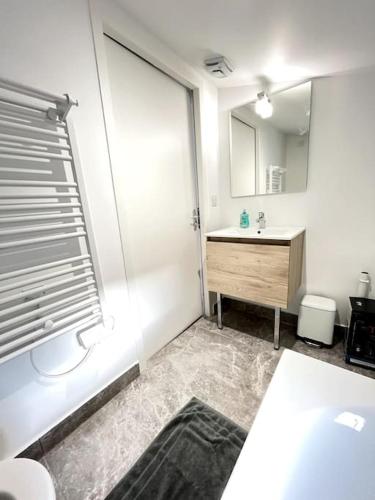 une salle de bain avec un lavabo et un miroir dans l'établissement Le Pré Vert - Tournon, à Tournon-sur-Rhône