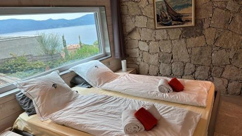 two beds in a room with a large window at VbyOnyx in Olmeto