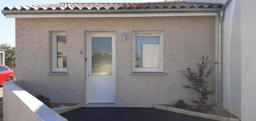 a house with a white door and windows at Le Cocon de Crussol, classé 3 étoiles in Granges-lès-Valence