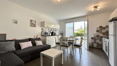 un salon et une cuisine avec un canapé et une table dans l'établissement Ma cabane de plage, à Saint-Valery-sur-Somme