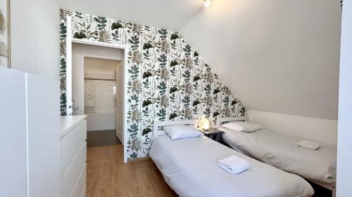 deux lits dans une petite pièce avec un miroir dans l'établissement Ma cabane de plage, à Saint-Valery-sur-Somme