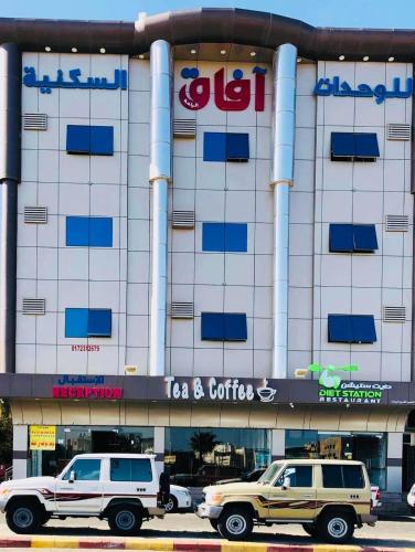two vehicles parked in front of a building at Afaq Al Raha in Khamis Mushayt