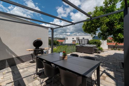 a patio with a table and chairs on a patio at Maca Apartments & Suites in Trogir