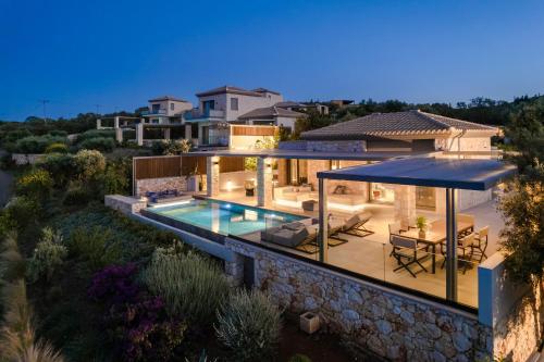 a villa with a swimming pool and a house at Epiphany Villas Lefkada in Tsoukaladhes