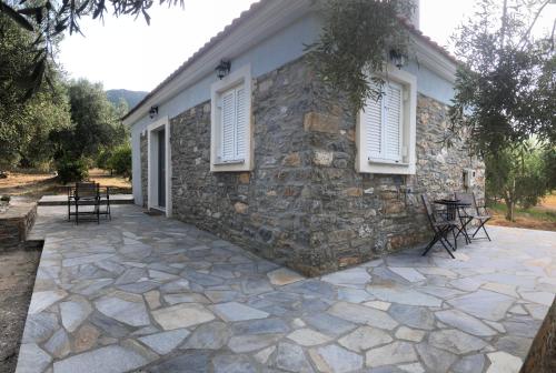 a stone patio in front of a stone house at Emmeleia's in Soúrpi