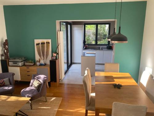 une salle à manger avec une table et une cuisine dans l'établissement Charmante maison au calme, à Colombes