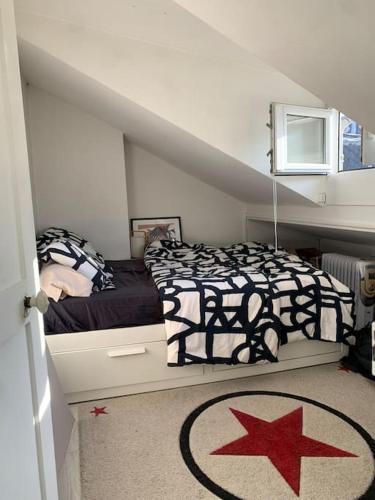 une chambre avec un lit dans un grenier dans l'établissement Charmante maison au calme, à Colombes