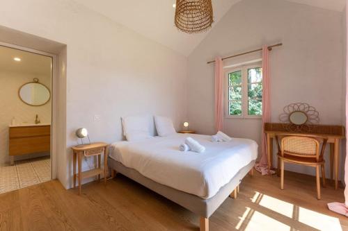 une chambre avec un grand lit blanc et un miroir dans l'établissement Proche Océan - Villa Fioretti -, à Noirmoutier-en-l'lle