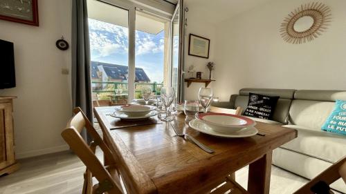 - une table à manger avec des verres à vin et un canapé dans l'établissement Wild Berry, oasis de tranquilité pour 4 personnes, au Crotoy