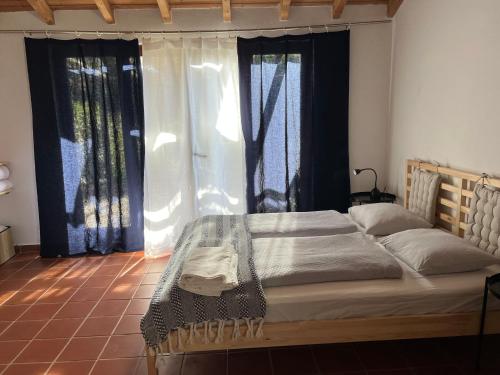 a large bed in a room with windows at Moinhos do Paneiro in Santiago do Cacém