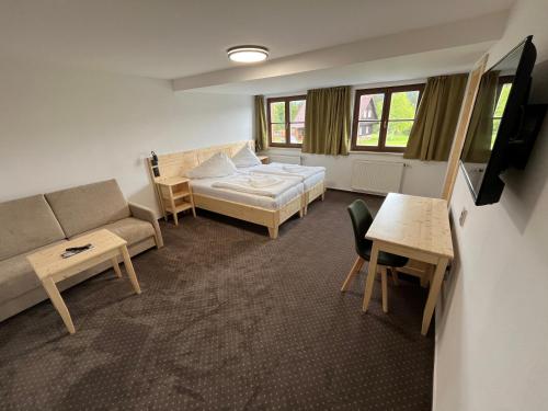 salon z kanapą, łóżkiem i stołem w obiekcie Hotel Rankl w mieście Horská Kvilda