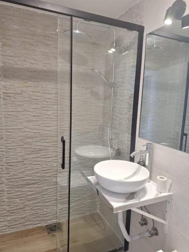 a bathroom with a sink and a glass shower at Lisbon South Bay Rooms 2 in Almada