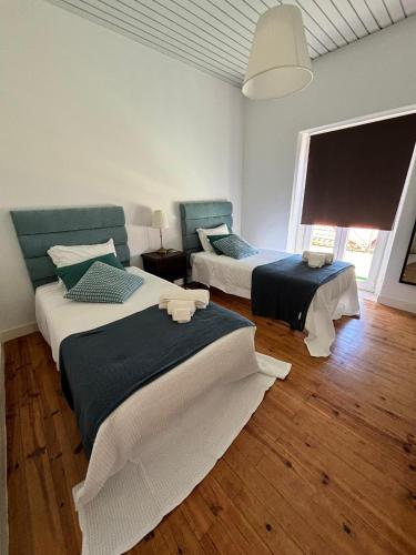 a bedroom with two beds and a large window at Casa das Memórias in Moita