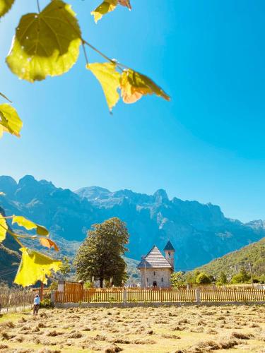 a house in a field with autumn leaves at Guesthouse Prrockaj Theth in Theth