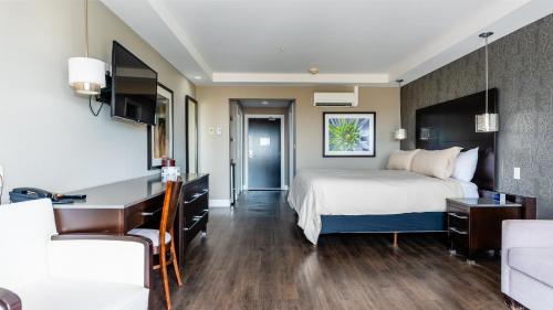 a hotel room with a bed and a desk at Hôtel Shediac in Shediac