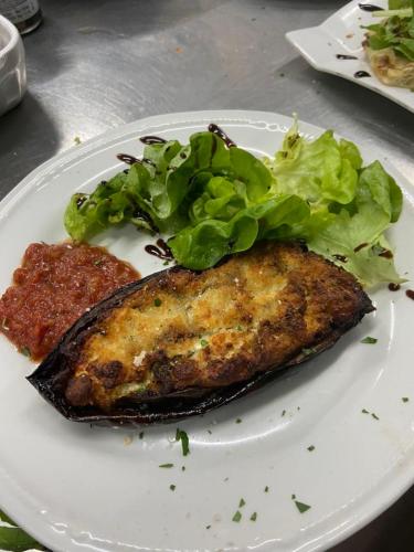 a plate of food with a piece of fish and a salad at Acquella in Cauro