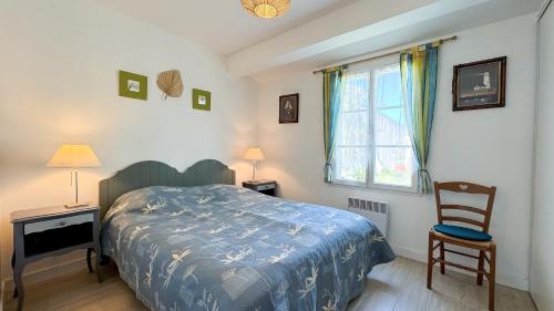 une chambre avec un lit, une chaise et une fenêtre dans l'établissement Jolie villa de plain pied avec agréable jardin, à Saint-Clément-des-Baleines