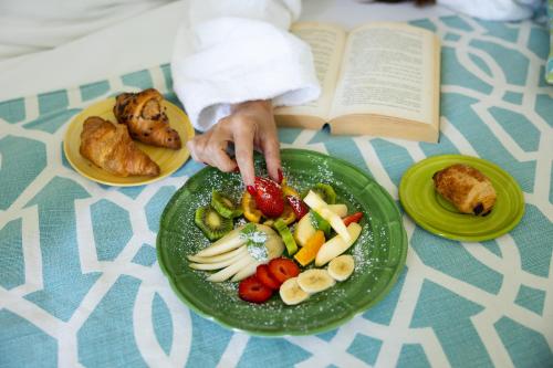 um prato de frutas e vegetais sobre uma mesa com um livro em Relais Correale Rooms & Garden em Sorrento