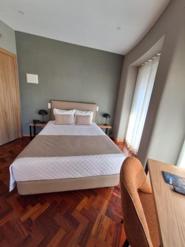 a bedroom with a large bed and a wooden floor at Hotel Alicante Lisboa in Lisbon