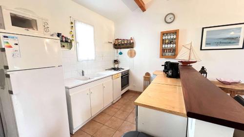 une cuisine avec un réfrigérateur blanc et un évier dans l'établissement Jolie villa de plain pied avec agréable jardin, à Saint-Clément-des-Baleines