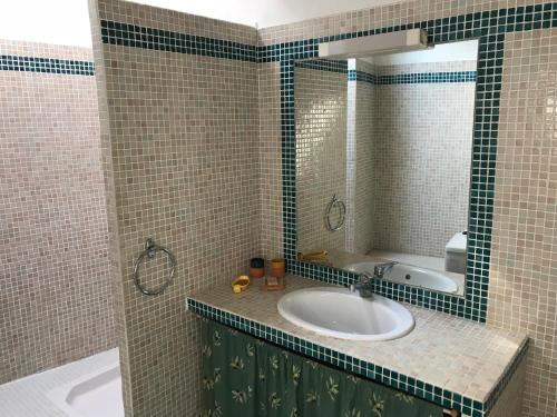 une salle de bain avec un lavabo et un miroir dans l'établissement maison familiale, à Saint-Trinit