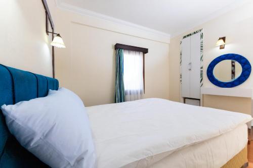 a bedroom with a white bed and a window at Salinas Hotel in Gümbet