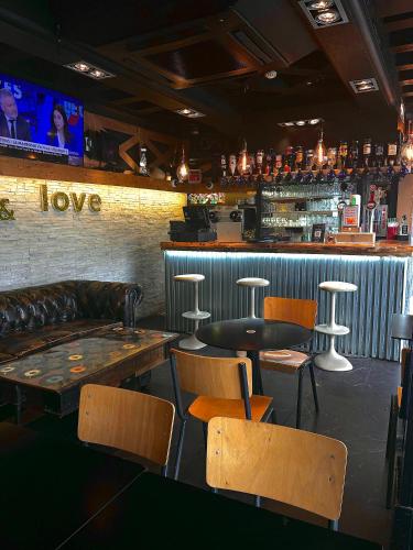 a bar with a couch and tables and chairs at Peace & Love Hostel in Paris