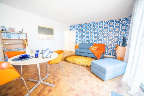 a living room with a table and a couch at Studio 22-Clim-Wifi-Terrasse-Plage in La Grande-Motte