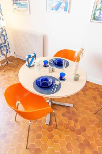 a table with two chairs and a white table with plates at Studio 22-Clim-Wifi-Terrasse-Plage in La Grande-Motte