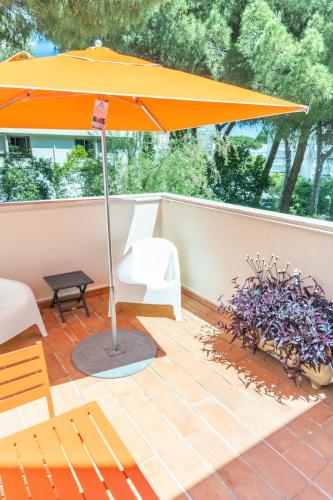 an orange umbrella on top of a patio at Studio 22-Clim-Wifi-Terrasse-Plage in La Grande-Motte