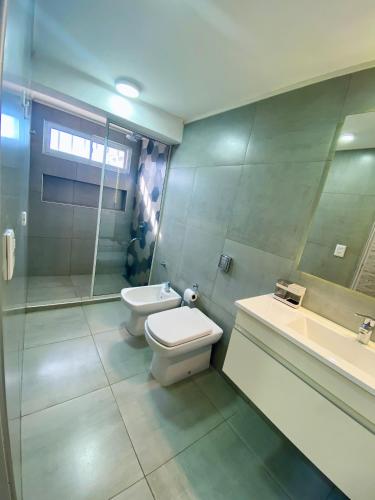 a bathroom with a toilet and a sink and a shower at Alquiler Temporario Las Parejas in Las Parejas