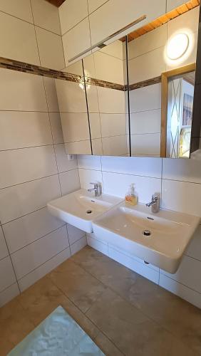 a white bathroom with a sink and a mirror at Apartments Jacqueline in Sankt Kanzian