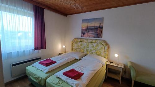 a bedroom with a bed with two red pillows on it at Apartments Jacqueline in Sankt Kanzian