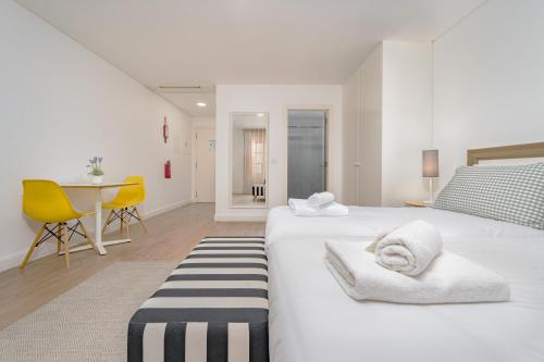 two beds in a room with a table and chairs at Studios Funchal in Funchal