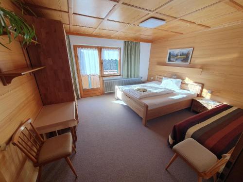 a bedroom with a bed and two chairs in a room at Haus Salzmann in Sankt Gallenkirch