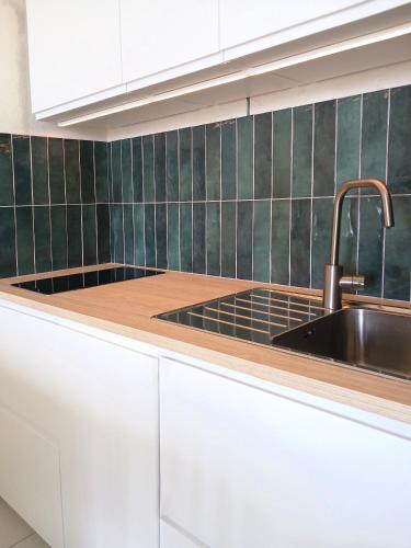 une cuisine avec des armoires blanches et un évier dans l'établissement Appart du golf, à Saint-Jean-de-Monts