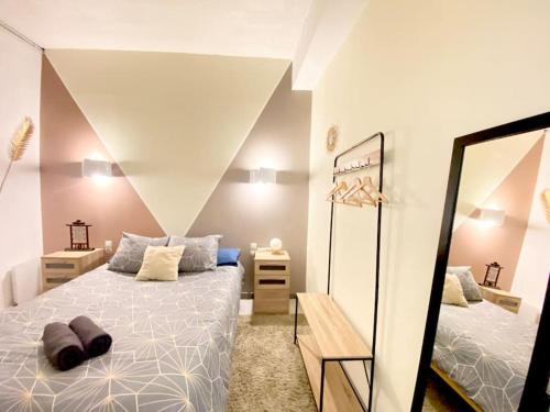 Un dormitorio con una cama grande y un espejo. en Le Jardin Secret De Nady, en Carcassonne