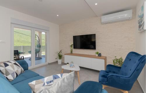 een woonkamer met blauwe stoelen en een tv bij Stunning Home In Poljica With Kitchen in Poljica
