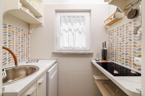 a bathroom with a sink and a window at Holliday house Smokvica in Jadranovo