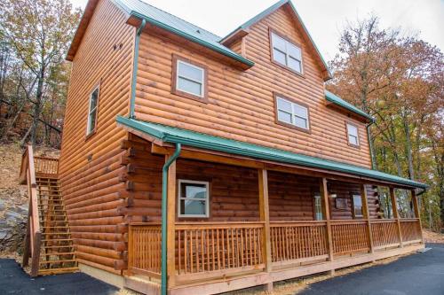 a large wooden cabin with a fence in front of it at Spacious 2800 sq ft-Cozy Wood Cabin-NEW BUILD in Pigeon Forge