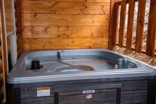 ein Whirlpool in einem Raum mit Holzwänden in der Unterkunft Spacious 2800 sq ft-Cozy Wood Cabin-NEW BUILD in Pigeon Forge