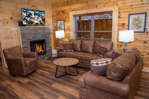 a living room with a couch and a fireplace at Spacious 2800 sq ft-Cozy Wood Cabin-NEW BUILD in Pigeon Forge