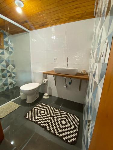 a bathroom with a sink and a toilet at Pousada Doce Vida in Urubici