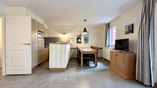 une cuisine avec une table et une salle à manger dans l'établissement Argousiers 11, à Fort-Mahon-Plage